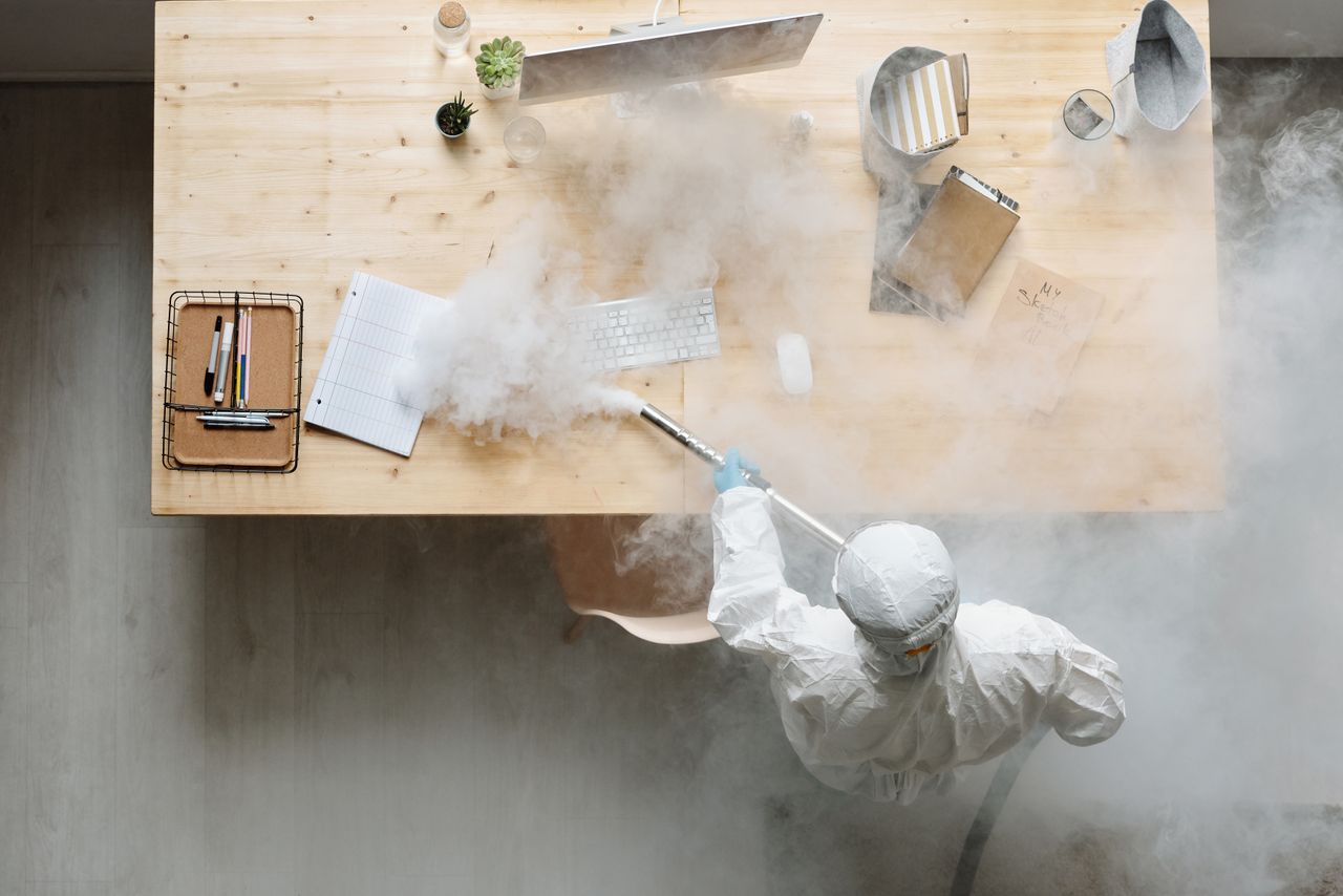 heros-img An individual disinfects a workspace using fumigation, wearing full protective gear for safety.