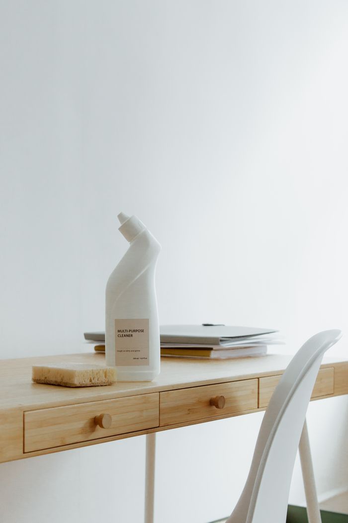 about-us-02 A clean and organized home office desk with a cleaner bottle and sponge, emphasizing simplicity and functionality.